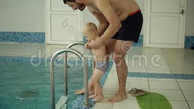 父母教儿子在游泳池里游泳。 游泳池里的年轻家庭教他的儿子游泳。 在外面的父亲